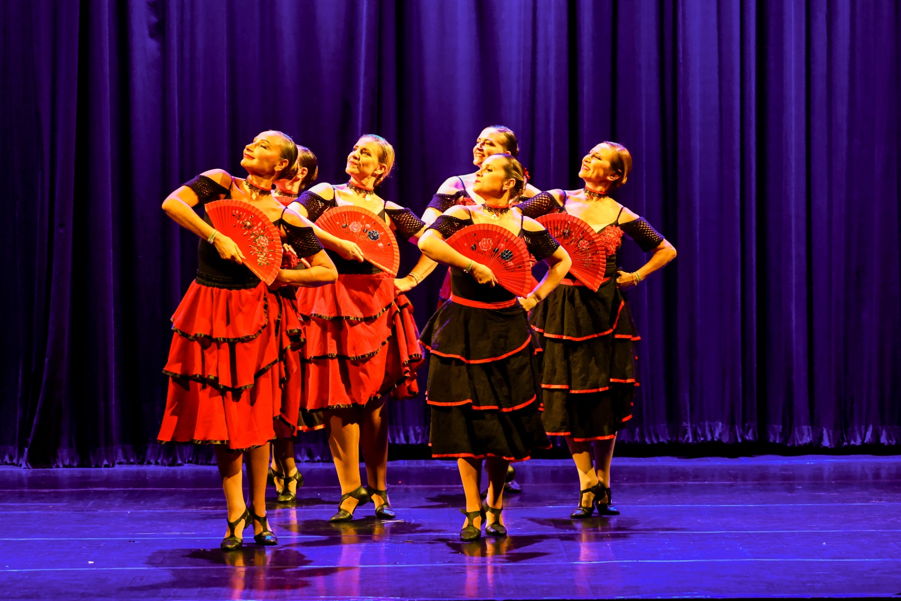 Grupo de bailarinas com leques vermelhos